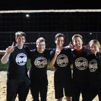 Students wearing championship shirts from an upper bracket sand volleyball tournament